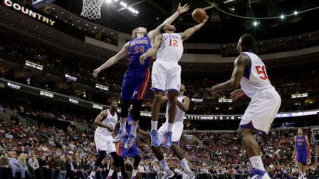 Philadelphia 76ers Evan Turner (12) pulls in a rebound against Detroit Pistons Kyle Singler (25) in the first half of an NBA basketball game, Monday, Dec. 10, 2012, in Philadelphia. (AP Photo/Matt Slocum)