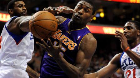 Los Angeles Lakers Metta World Peace, center, pulls in a rebound over Philadelphia 76ers Dorell Wright, left, and Thaddeus Young (21) during the first half of an NBA basketball game on Sunday, Dec. 16, 2012, in Philadelphia. (AP Photo/Michael Perez)