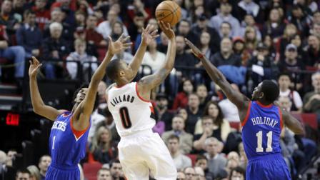 Portland Trail Blazers guard Damian Lillard, middle, shoots against Philadelphia 76ers guards Nick Young, left, and Jrue Holiday during the first quarter of an NBA basketball game in Portland, Ore., Saturday, Dec. 29, 2012.(AP Photo/Don Ryan)