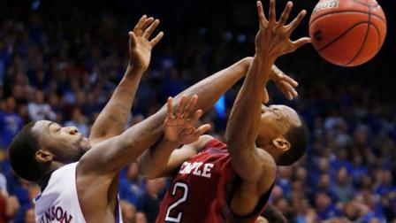 Temple guard Will Cummings (2) is fouled by Kansas guard Elijah Johnson (15) during the second half of an NCAA college basketball game in Lawrence, Kan., Sunday, Jan. 6, 2013. Kansas defeated Temple 69-62. (AP Photo/Orlin Wagner)