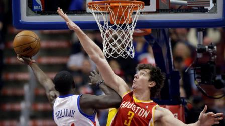 Philadelphia 76ers Jrue Holiday, left, goes up for a shot against Houston Rockets Omer Asik, of Turkey, in the first half of an NBA basketball game, Saturday, Jan. 12, 2013, in Philadelphia. (AP Photo/Matt Slocum)