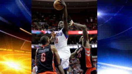 Philadelphia 76ers Jrue Holiday, center, shoots between Toronto Raptors Alan Anderson, left, and Amir Johnson in overtime of an NBA basketball game on Friday, Jan. 18, 2013, in Philadelphia. Philadelphia won 108-101. (AP Photo/Matt Slocum)