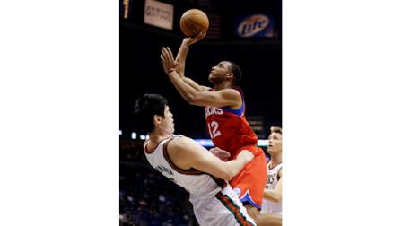 Philadelphia 76ers Evan Turner (12) shoots against Milwaukee Bucks Ersan Ilyasova, left, during the first half of an NBA basketball game, Tuesday, Jan. 22, 2013, in Milwaukee. (AP Photo/Jeffrey Phelps)
