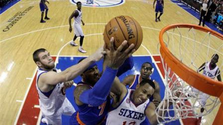 New York Knicks Carmelo Anthony, center, battles for a rebound with Philadelphia 76ers Spencer Hawes, left, and Evan Turner during the first half of an NBA basketball game, Saturday, Jan. 26, 2013, in Philadelphia. (AP Photo/Matt Slocum)