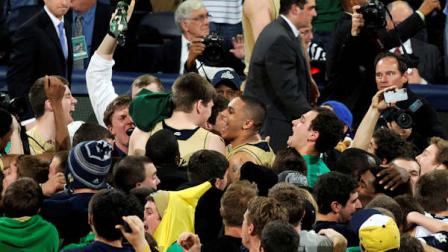 Notre Dame players including Zach Auguste, center right, and Jack Cooley, center left, celebrate with fans after their 104-101 win over Louisville in the fifth overtime of their NCAA college basketball game, Saturday, Feb. 9, 2013, in South Bend, Ind. (AP Photo/Joe Raymond)