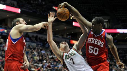 Philadelphia 76ers Spencer Hawes, left, and Lavoy Allen (50) block the shot of Milwaukee Bucks Ersan Ilyasova (7) during the second half of an NBA basketball game on Wednesday, Feb. 13, 2013, in Milwaukee. (AP Photo/Jim Prisching)