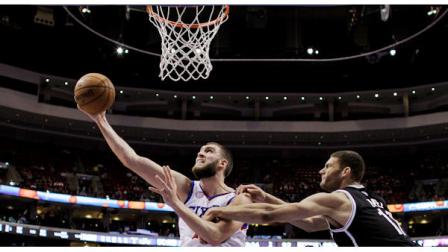 Philadelphia 76ers Spencer Hawes, left, shoots as Brooklyn Nets Brook Lopez hangs on during the second half of an NBA basketball game, Monday, March 11, 2013, in Philadelphia. Philadelphia won 106-97. (AP Photo/Matt Slocum)