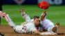 Philadelphia Phillies Ben Revere, left, loses his helmet while colliding with Atlanta Braves Andrelton Simmons, right, on a dive back to second base after leading off in the third inning of an opening day baseball game, Monday, April 1, 2013, in Atlanta. (AP Photo/David Goldman)  