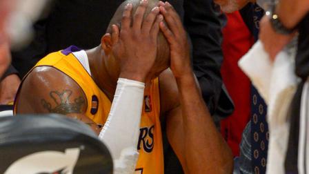 Los Angeles Lakers guard Kobe Bryant, left, puts his head in his hands as trainer Gary Vitti looks on after being injured during the second half of their NBA basketball game against the Golden State Warriors, Friday, April 12, 2013, in Los Angeles. The Lakers won 118-116. (AP Photo/Mark J. Terrill)