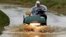 A golf cart makes it way through a flooded cart path as rain falls at Merion Country Club, in Ardmore, Pa., early Monday, June 10, 2013. The 2013 U.S. Open Championship will be played at Merion, June 13-16. (AP Photo/Gene Puskar)  