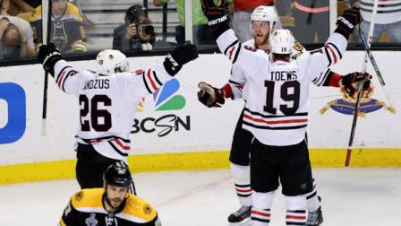 Chicago Blackhawks left wing Bryan Bickell, center, celebrates his goal with Chicago Blackhawks center Jonathan Toews (19) and Chicago Blackhawks center Michal Handzus (26), of Slovakia, during the third period in Game 6 of the NHL hockey Stanley Cup Finals against the Boston Bruins, Monday, June 24, 2013, in Boston. (AP Photo/Charles Krupa)
