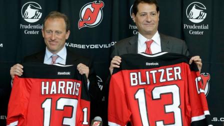 Joshua Harris, left, and David Blitzer, hold New Jersey Devils jerseys with their names during an NHL hockey news conference announcing them as new owners of the team, Thursday, Aug. 15, 2013, in Newark, N.J. Harris, the founder of one of the worlds largest private equity firms, also owns the Philadelphia 76ers NBA basketball team. (AP Photo/Julio Cortez)