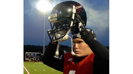 Mansfield Universitys Kirk Haskill is illuminated by the lights as he puts on his helmet prior to a college sprint football game against Princeton in Mansfield, Pa. on Saturday, Sept.14, 2013. The game marks the first time that Mansfield has held an official night football game since 1892 when Mansfield staged the first-ever night football game.