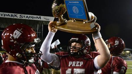 St. Josephs Preparatorys Chris Martin (15) holds up the first place trophy at the end of a PIAA high school Class AAAA championship football game against Central Catholic in Hershey, Pa., on Sunday, Dec. 15, 2013. St. Joseph won 35-10.
