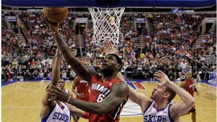 Miami Heats LeBron James (6) goes up to shoot against Philadelphia 76ers Evan Turner (12) and Spencer Hawes (00) during the first half of an NBA basketball game on Friday, Jan. 17, 2014, in Philadelphia. (AP Photo/Matt Slocum)