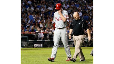 Philadelphia Phillies Roy Halladay, left, leaves the game with trainer Scott Sheridan during the fifth inning of a baseball game against the Chicago Cubs Monday, July 18, 2011 in Chicago. (AP Photo/Charles Rex Arbogast)