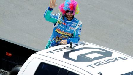 Jimmie Johnson wears a wig and waves to fans as he takes a lap around the track on the back of a truck during driver introductions before the NASCAR Sprint Cup Series FedEx 400 auto race, Sunday, June 3, 2012, in Dover, Del. Johnson went on to win the race. (AP Photo/Nick Wass)