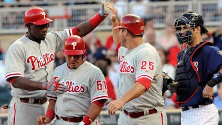Minnesota Twins catcher Joe Mauer, right, watches as Philadelphia Phillies Jim Thome (25), Carlos Ruiz (51) and John Mayberry Jr., left, celebrate Mayberrys three-run home run off Minnesota Twins relief pitcher Jeff Manship in the first inning of a baseball game on Wednesday, June 13, 2012, in Minneapolis. (AP Photo/Jim Mone)