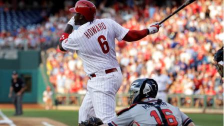 Philadelphia Phillies Ryan Howard follows through after hitting a double off Atlanta Braves pitcher Tim Hudson in the second inning of a baseball game, Friday, July 6, 2012, in Philadelphia. At right is Braves catcher Brian McCann. (AP Photo/Laurence Kesterson)