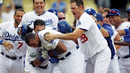 Los Angeles Dodgers Matt Kemp, center, is swarmed by teammates, including Jamey Wright (28), after hitting a walkoff home run to give the Dodgers a 5-3 win over the Philadelphia Phillies in the 12th inning of a baseball game in Los Angeles, Wednesday, July 18, 2012. (AP Photo/Reed Saxon)
