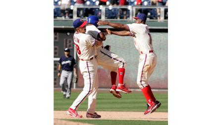 Philadelphia Phillies Jonathan Papelbon, left, lifts teammate Jimmy Rollins up as Juan Pierre, right, joins in to celebrate Rollins game-winning RBI in the 10th inning of a baseball game, Wednesday, July 25, 2012, in Philadelphia. The Phillies won 7-6. (AP Photo/Tom Mihalek)