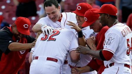 Cincinnati Reds Jay Bruce (32) is mobbed by teammates after he drove in the winning run with a single off Philadelphia Phillies relief pitcher Phillippe Aumont in the bottom of the ninth inning of a baseball game on Wednesday, April 17, 2013, in Cincinnati. Cincinnati won 1-0. The game was finished Wednesday after being stopped by rain in the bottom of the ninth inning on Tuesday evening. (AP Photo/Al Behrman)