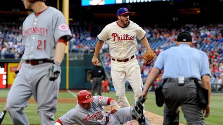 Cincinnati Reds Todd Frazier (21) walks out of the batters box as Joey Votto (19) scores on a wild pitch from Philadelphia Phillies Phillippe Aumont, center, in the eighth inning of a baseball game on Saturday, May 18, 2013, in Philadelphia. The Reds won 10-0. (AP Photo/Michael Perez)