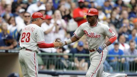 Philadelphia Phillies Domonic Brown, right, celebrates his home run with third base coach Ryne Sandberg,left, against the Milwaukee Brewers during the second inning of a baseball game Saturday, June 8, 2013, in Milwaukee. (AP Photo/Jeffrey Phelps)
