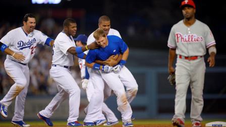 Los Angeles Dodgers A.J. Ellis, second from right, has his jersey ripped off by teammates after hitting an RBI single to end the game as Philadelphia Phillies shortstop Jimmy Rollins walks off the field during the ninth inning of their baseball game against the Philadelphia Phillies in Los Angeles on Saturday, June 29, 2013. (AP Photo/Mark J. Terrill)