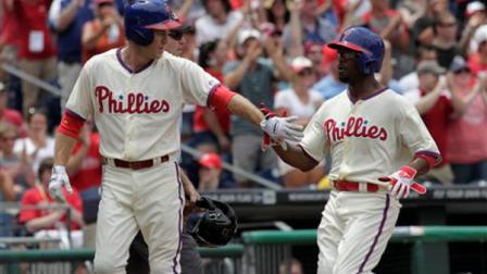 Philadelphia Phillies Chase Utley, left and Jimmy Rollins celebrate after they scored against the Chicago White Sox in the first inning of an interleague baseball game on Sunday, July 14, 2013, in Philadelphia. (AP Photo/H. Rumph Jr)