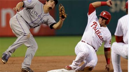 Philadelphia Phillies Carlos Ruiz is safe on third on a hit by Cody Asche bringing in Domonic Brown for the run before Colorado Rockies third baseman Nolan Arenado can make the tag in the second inning in a baseball game, Thursday, Aug. 22, 2013, in Philadelphia. (AP Photo/Laurence Kesterson)