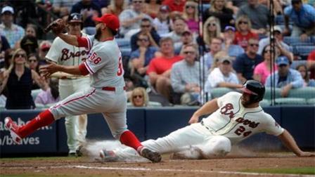 Atlanta Braves Evan Gattis, right, scores on a wild pitch as Philadelphia Phillies pitcher Cesar Jimenez (56) covers home plate during the sixth inning of a baseball game on Sunday, Sept. 29, 2013, in Atlanta. (AP Photo/John Amis)