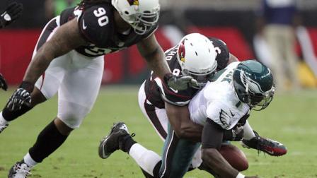 Philadelphia Eagles quarterback Michael Vick, right, has the ball knocked out of his hands as he is tackled by Arizona Cardinals linebacker Sam Acho, center, as Cardinals defensive tackle Darnell Dockett, left, looks on in the second quarter of an NFL football game on Sunday, Sept. 23, 2012, in Glendale, Ariz. (AP Photo/Paul Connors)