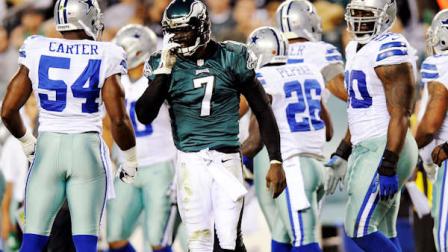 Philadelphia Eagles quarterback Michael Vick (7) adjusts his helmet after being tackled in the first half of an NFL football game against the Dallas Cowboys, Sunday, Nov. 11, 2012, in Philadelphia. (AP Photo/Michael Perez)
