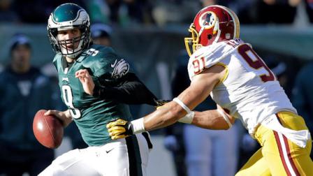 Philadelphia Eagles Nick Foles, left, scrambles from Washington Redskins Ryan Kerrigan in the first half of an NFL football game, Sunday, Dec. 23, 2012, in Philadelphia. (AP Photo/Mel Evans)