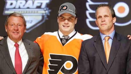 Scott Laughton, center, a center, stands with Philadelphia Flyers officials after being chosen 20th overall in the first round of the NHL hockey draft on Friday, June 22, 2012, in Pittsburgh. (AP Photo/Keith Srakocic)