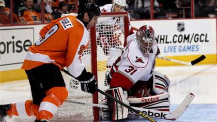 Philadelphia Flyers Mike Knuble, left, wraps around the net to score on Carolina Hurricanes Cam Ward in the second period of an NHL hockey game on Saturday, Feb. 2, 2013, in Philadelphia. (AP Photo/Tom Mihalek)