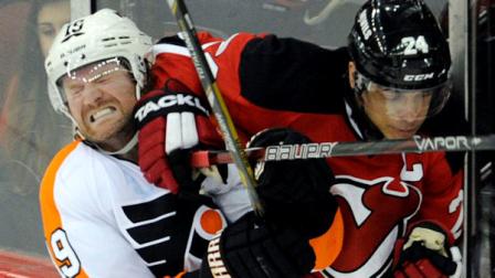 Philadelphia Flyers Scott Hartnell, left, runs into the elbow of New Jersey Devils Bryce Salvadore during the second period of an NHL hockey game on Wednesday, March 13, 2013, in Newark, N.J. (AP Photo/Bill Kostroun)