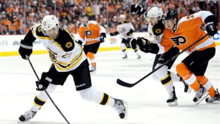 Boston Bruins Jay Pandolfo (29) shoots on goal as Jordan Caron, center, defends against Philadelphia Flyers Kurtis Foster (3) in the first period of an NHL hockey game, Saturday, March 30, 2013, in Philadelphia. (AP Photo/Michael Perez)