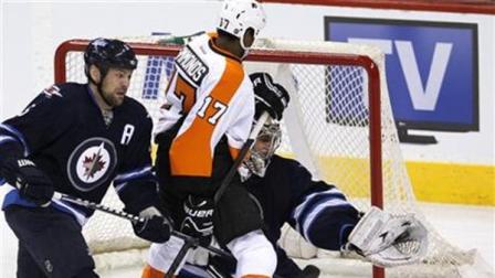 Winnipeg Jets goaltender Ondrej Pavelec makes a save as Philadelphia Flyers forward Wayne Simmonds and Jets defenseman Mark Stuart fight for position during the first period of an NHL hockey game action in Winnipeg on Saturday, April 6, 2013. (AP Photo/The Canadian Press, John Woods)