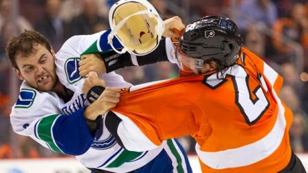 Vancouver Canucks Zack Kassian, left, loses his helmet as he fights with Philadelphia Flyers Luke Schenn, right, during the first period of an NHL hockey game, Tuesday, Oct. 15, 2013, in Philadelphia. (AP Photo/Chris Szagola)