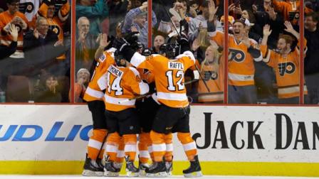 Philadelphia Flyers players celebrate with Claude Giroux after he scored a goal during the third period of an NHL hockey game against the Columbus Blue Jackets, Thursday, Dec. 19, 2013, in Philadelphia. Philadelphia won 5-4. (AP Photo/Matt Slocum)