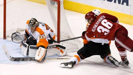 Philadelphia Flyers Steve Mason (35) makes a stick-save on a shot by Phoenix Coyotes Rob Klinkhammer (36) while Flyers Luke Schenn defends during the third period of an NHL hockey game Saturday, Jan. 4, 2014, in Glendale, Ariz. The Flyers defeated the Coyotes 5-3. (AP Photo/Ross D. Franklin)