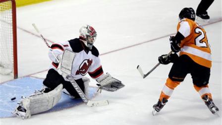 Philadelphia Flyers Claude Giroux, right, scores a goal past New Jersey Devils Johan Hedberg, of Sweden, during a shootout of an NHL hockey game, Friday, March 15, 2013, in Philadelphia. Philadelphia won 2-1 in a shootout. (AP Photo/Matt Slocum)