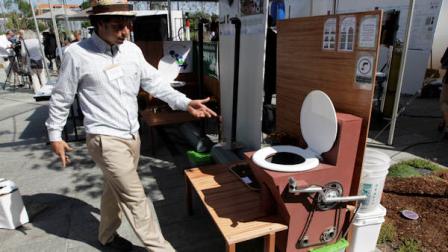 Marcos Fiovavanti, of the Ecuador-based Fundacion In Terris group, talks about the Earth Auger Toliet, which is operated by a mechanical pedal and chain system, on display at the Reinventing the Toliet Fair, Tuesday, Aug. 14, 2012, in Seattle, which is part of a Bill and Melinda Gates Foundation competition to reinvent the toilet for the 2.6 billion people around the world who dont have access to modern sanitation. (AP Photo/Ted S. Warren)