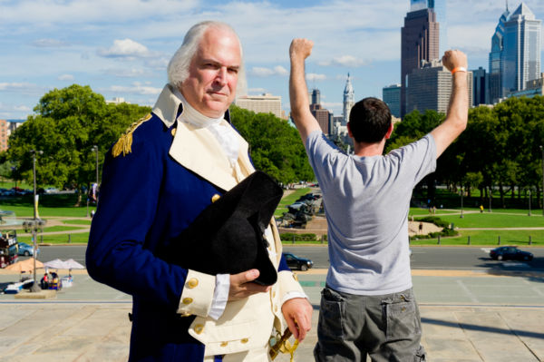 George Washington climbs the steps of the Philadelphia Museum of Art and watches in amusement as tourists recreate the iconic scene