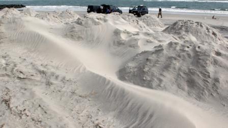 As men surf fish near the ocean, sand blows on mounds for beach protection in North Wildwood, N.J., Saturday, Oct. 27, 2012, as the area prepares for Hurricane Sandy. From the lowest lying areas of the Jersey shore, where residents were already being encouraged to leave, to the states northern highlands, where sandbags were being filled and cars moved into parking lots on high ground, New Jersey began preparing in earnest for Hurricane Sandy. (AP Photo/Mel Evans)