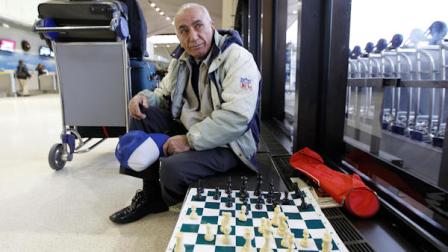 Morris Farimi, 70, of Philadelphia, waits for a challenger in a game of chess after finding out his flight to Germany had been canceled at Newark Liberty International Airport, Sunday, Dec. 26, 2010. Airlines are working to rebook stranded passengers and possibly add flights after a winter storm on the East Coast caused thousands of flight cancellations and left countless passengers stranded. (AP Photo/Julio Cortez)