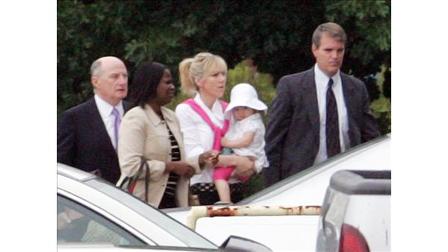 Rielle Hunter, center, is escorted into the Terry Sanford Federal Building and Courthouse in Raleigh, N.C., Thursday, Aug. 6, 2009. Former Sen. John Edwards had an extramarital affair with Hunter that he says ended in 2006. (AP Photo/Jim R. Bounds)