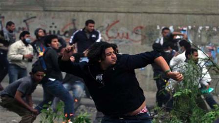 Protesters throw stones at Egyptian riot police during clashes near the interior ministry in downtown cairo, Egypt, Sunday, Nov. 20, 2011. Firing tear gas and rubber bullets, Egyptian riot police on Sunday clashed for a second day with thousands of rock-throwing protesters demanding that the ruling military quickly announce a date to hand over power to an elected government. The police battled an estimated 5,000 protesters in and around central Cairos Tahrir Square, birthplace of the 18-day uprising that toppled authoritarian leader Hosni Mubarak in February.
